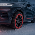 Chaussette à neige textile Reinhardt installée sur la roue d'un SUV dans la neige